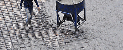 Ouvrier surveillant la coulée du béton sur un plancher béton