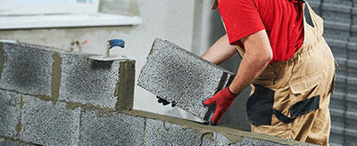Ouvrier en train de construire un mur en parpaings